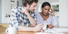 A couple looking at their bills on the table