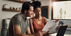 A couple going through paperwork while doing their budget at home