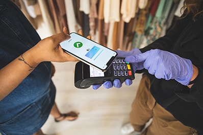 June Article Monthly Image - Image of a lady paying for something using her smart phone on a mobile register