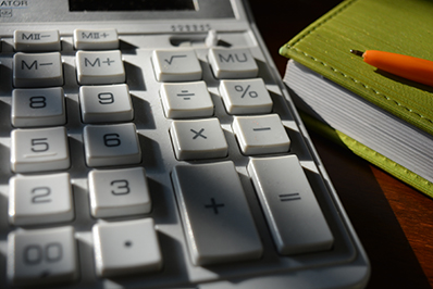 calculator and a notepad with a pen on top