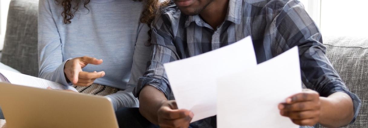 A couple reviewing papers and pointing at a computer